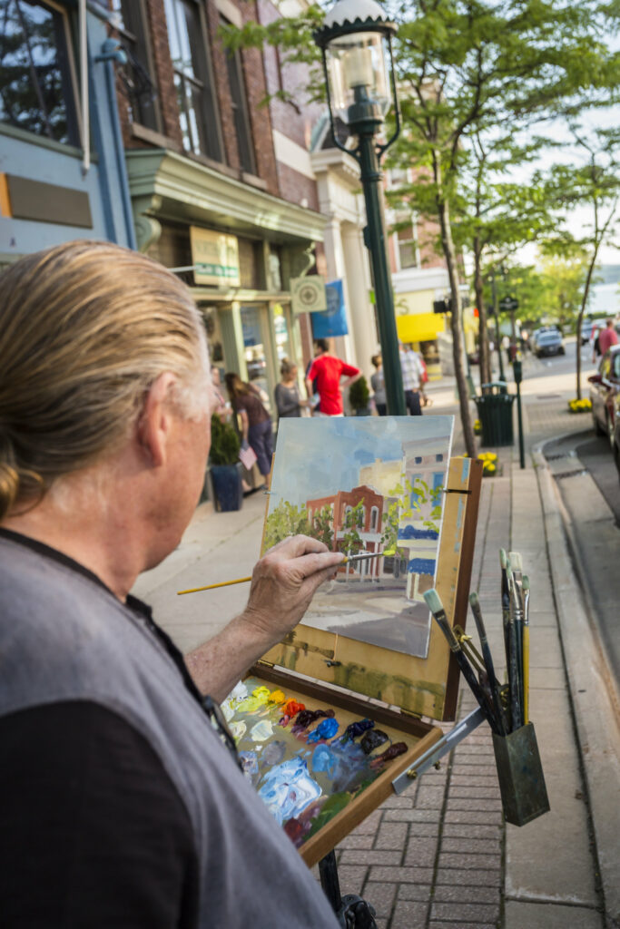 An artist paints along the gallery walk in downtown petoskey